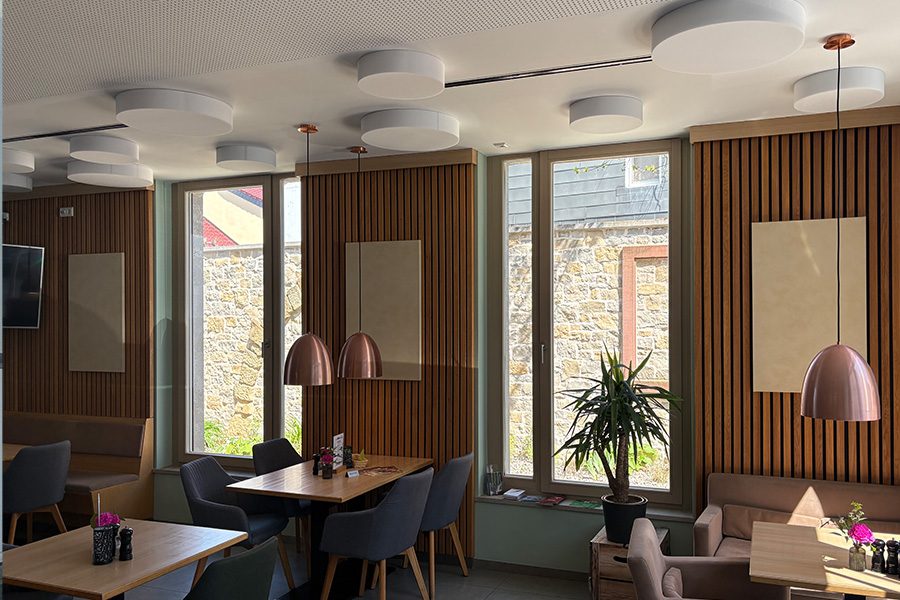 Raumakustikelemente = Holzpanelen in einem Café.
